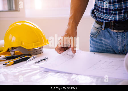 architect man reading with blueprint to build houses. After agreeing the employment price the cost of construction and repair real estate Stock Photo