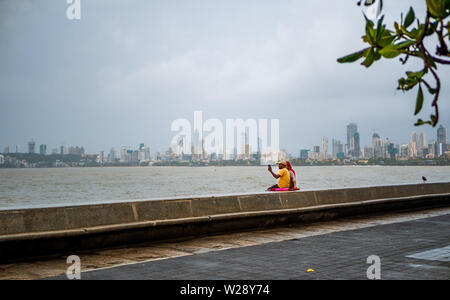 Mumbai, India - June 30, 2019 : Unidentified couple taking photos / selfie with Mobile at Marine Drive promenade Stock Photo