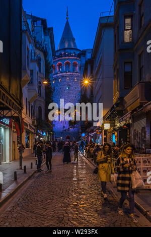 Night view of a street near Galata Tower, a medieval stone tower in Istanbul and popular tourist attraction. Istanbul, Turkey, October 2018 Stock Photo