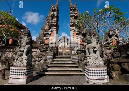 Ubud, Bali, Indonesia - 5th May 2019 : Picture of a typical Balinese temple building, with bedogol statues at the entrance of the temple gate. This te Stock Photo