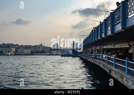 Istanbul Galata Bridge has two levels: on the upper level, fishermen fishing in Bosporus, on the lower level there are many café and restaurants Stock Photo
