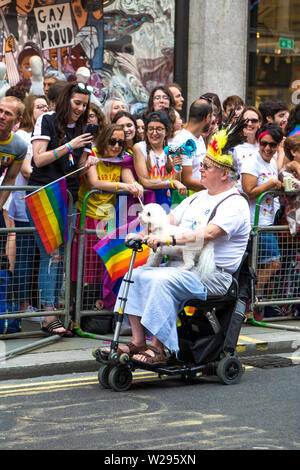 6 July 2019 - Man on a mobility scooter holding a poodle, London Pride Parade, UK Stock Photo