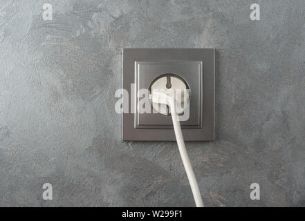220 volt power plug on a stucco wall background Stock Photo
