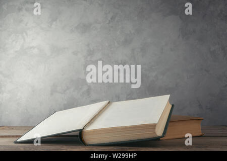 Open books on the table against the wall Stock Photo