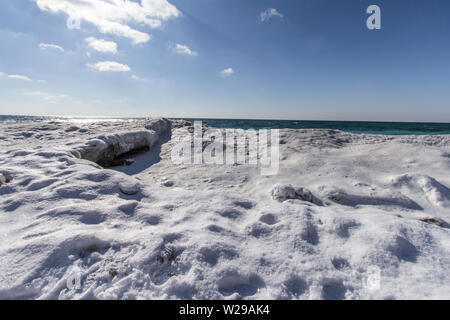 Winter Day At The Beach. Snowbank and ice piled up on the coast of Lake Michigan at Sleeping Bear Dunes National Lakeshore in Michigan. Stock Photo