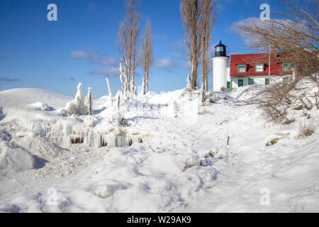 Winter Lighthouse Landscape. Beautiful Point Betsie Lighthouse surrounded by ice and snow on a cold winter day on the coast of Lake Michigan.