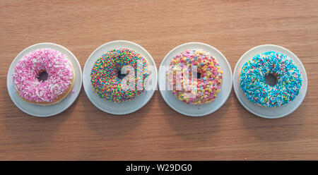 Assorted donuts. Colorful donuts assortment on wooden background. Top view Stock Photo