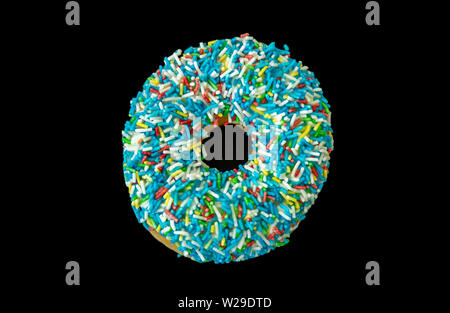 Blue donut. One donut with colorful sprinkles isolated on black color background. Top view Stock Photo