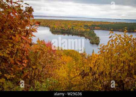 Michigan Autumn Scenic Panorama. Vibrant autumn color in the northern Michigan forest with the vast blue waters of Lake Superior in the background.