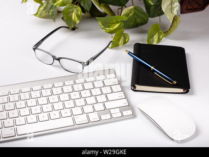 Computer keyboard, mouse and office objects on a white desktop Stock Photo