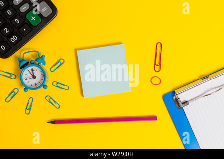 Alarm clipboard calculator clips band pencil notepad colored background Stock Photo