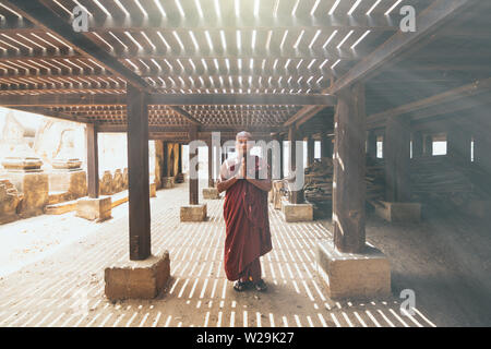 Bagan, Myanmar - March 2019: Burmese Buddhist monk praying in a monastery on a sunny day