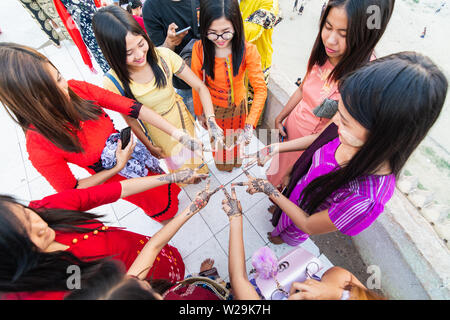 Bagan, Myanmar - March 2019: Burmese women holding henna painted hands in a star shape