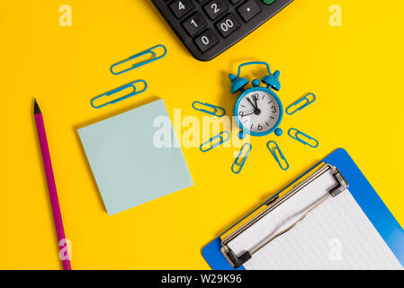 Alarm clock clipboard clips pencil calculator notepad colored background Stock Photo