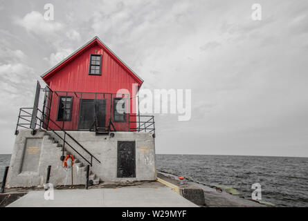 Great Lakes Lighthouse Under Moody Grey Sky. Grand Haven Lighthouse on the shores of Lake Michigan on the Great Lakes coast Stock Photo