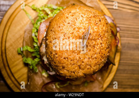 Bacon burger with beef patty on wooden table. Stock Photo