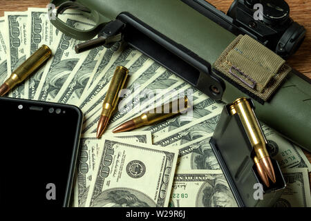 Rifle, magazine and cartridges on money. Concept for crime, contract killing, paid assassin, terrorism, war, global arms trade, weapons sale. Illegal Stock Photo