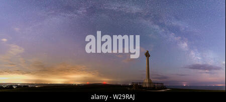 The arching Milky Way above Tennyson's monument on the Isle of Wight Stock Photo