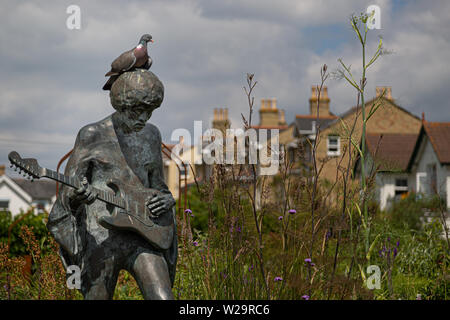 A sculpture of the late Jimi Hendrix with a resting pigeon on top outside Dimbola Museum and Galleries in Freshwater on the Isle of Wight Stock Photo