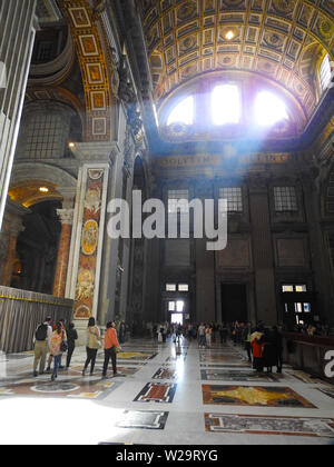 Interior of St Peter's Basilica with sun flare above The Holy Door, Vatican City, Rome, Italy Stock Photo