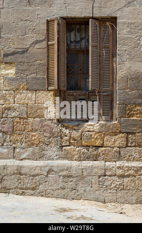 Broken windows and grunge stone bricks wall in abandoned Darb El Labana district, Cairo, Egypt Stock Photo