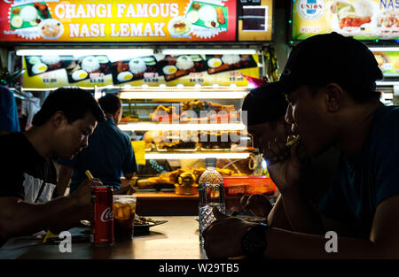 Singapore-29 JUN 2019: people eating local cuisine nasi lemak in food court Stock Photo