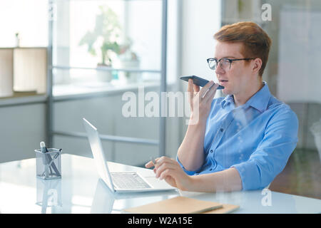 Contemporary office worker using voice message app Stock Photo