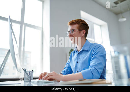 Happy guy in formalwear looking at computer screen Stock Photo