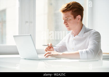 Pensive student working over educational project or preparing home assignment Stock Photo