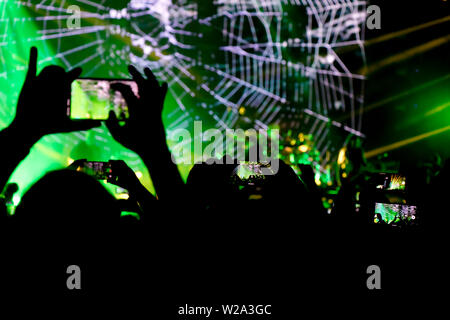 Collecting digital memory is loosing capability of being present, silhouette of people shooting the pop rock concert with mobile phones Stock Photo