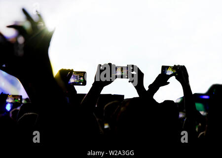 Collecting digital memory is loosing capability of being present, silhouette of people shooting the concert with mobile phones Stock Photo