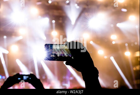 Collecting digital memory is loosing capability of being present, silhouette of people shooting the concert event with mobile phones Stock Photo