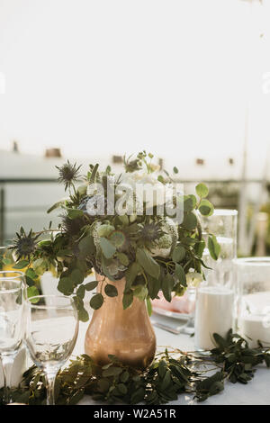 Flowers in a vase on the table as a decoration. Event or celebration. Stock Photo