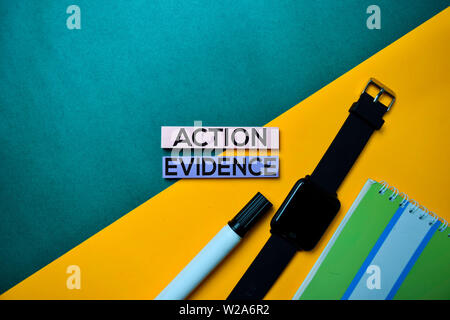 Action Evidence text on top view color table background. Stock Photo