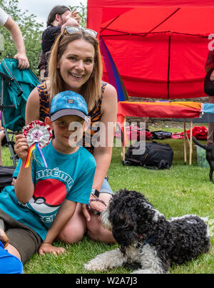 Bristol Pride Dog Show. 6 July 2019. Family taking part in dog show hold up their prize winning rosette for their dog. Castle Park. Bristol. United Kngdom Stock Photo