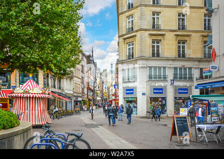 The tourist center of Rouen France on the Rue du Gros Horloge with the historical clock and cathedral tower in the distance Stock Photo