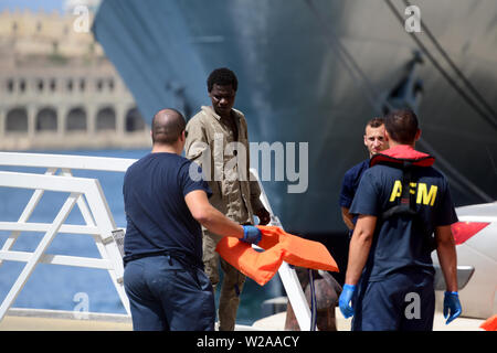 Floriana, Malta. 7th July, 2019. A rescued migrant (2nd L) disembarks in Floriana, Malta, on July 7, 2019. A group of 58 migrants was rescued by the Armed Forces of Malta (AFM) on Sunday morning. Credit: Jonathan Borg/Xinhua/Alamy Live News Stock Photo