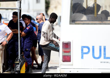 Floriana, Malta. 7th July, 2019. A rescued migrant (C) gets on a police vehicle in Floriana, Malta, on July 7, 2019. A group of 58 migrants was rescued by the Armed Forces of Malta (AFM) on Sunday morning. Credit: Jonathan Borg/Xinhua/Alamy Live News Stock Photo