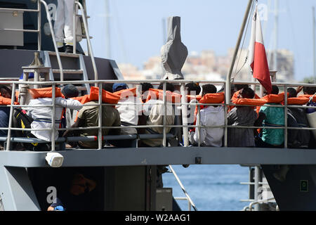 Floriana, Malta. 7th July, 2019. Rescued migrants sit on the deck of the Armed Forces of Malta patrol boat P21, in Floriana, Malta, on July 7, 2019. A group of 58 migrants was rescued by the Armed Forces of Malta (AFM) on Sunday morning. Credit: Jonathan Borg/Xinhua/Alamy Live News Stock Photo