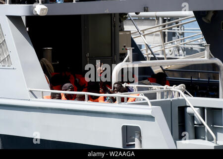 Floriana, Malta. 7th July, 2019. A resecued migrant waves his hand as the Armed Forces of Malta patrol boat P21 arrives in Floriana, Malta, on July 7, 2019. A group of 58 migrants was rescued by the Armed Forces of Malta (AFM) on Sunday morning. Credit: Jonathan Borg/Xinhua/Alamy Live News Stock Photo