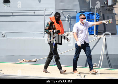 Floriana, Malta. 7th July, 2019. A rescued migrant (L) disembarks in Floriana, Malta, on July 7, 2019. A group of 58 migrants was rescued by the Armed Forces of Malta (AFM) on Sunday morning. Credit: Jonathan Borg/Xinhua/Alamy Live News Stock Photo