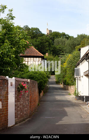 Castle Hedingham village street scene with medieval houses, looking up Castle Lane towards Hedingham Castle, Castle Hedingham, Essex UK Stock Photo