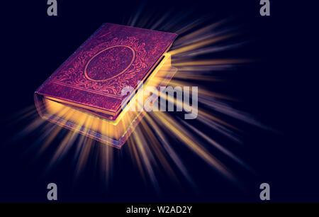 Old magic book with light rays isolated on black background. Stock Photo