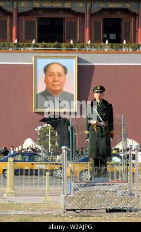 Guard standing in Tiananmen Square in front of the Gate of Heavenly Peace with a portrait of Mao Zedong (Chairman Mao). Tiananmen Square, Beijing. Stock Photo