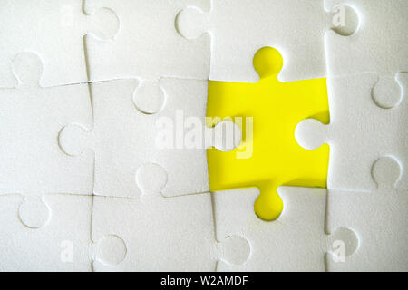Multiple white puzzle pieces put together without one piece. View from above. Stock Photo