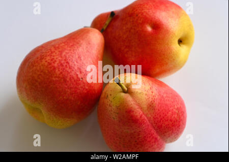 Close up of red and yellow pears on white plate Stock Photo
