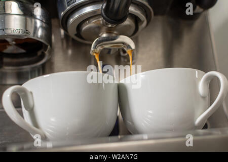 Two espresso cups getting filled in a portafilter machine Stock Photo -  Alamy
