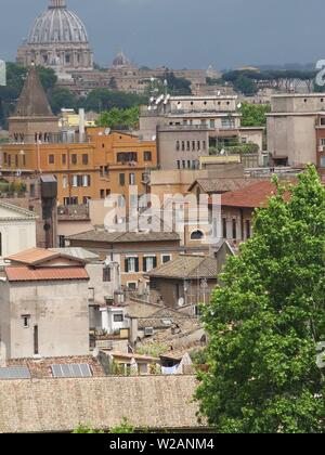 View across the rooftops looking towards St Peters Basilica at the Vatican in the distance; central Rome, May 2019 Stock Photo