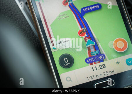 London, UK - June 11, 2019 - standstill traffic jam on m25 motorway; smartphone screen with GPS navigation showing delay Stock Photo
