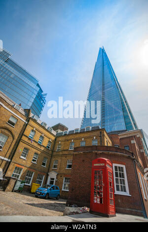 LONDON ENGLAND   July 16 2013; Ultra-modern The Shard landmark skyscraper building surrounded by low old traditional brick buildings and traditional B Stock Photo